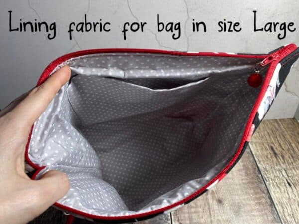 A hand is opening the project bag for knitting to show the lining fabric for large bags