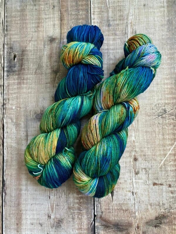 Two ocean inspired sock yarn skeins of yarn on a table, flat lay view.