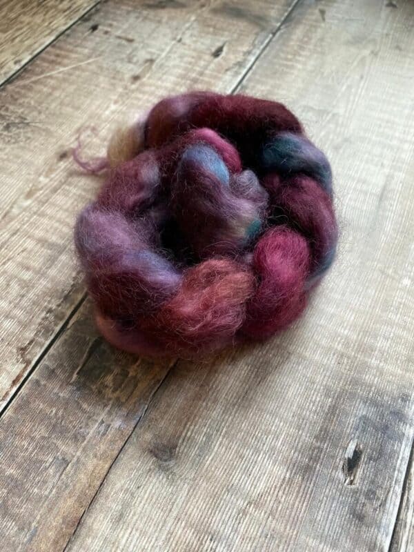 Jewel tone Wensleydale wool braid curled on table
