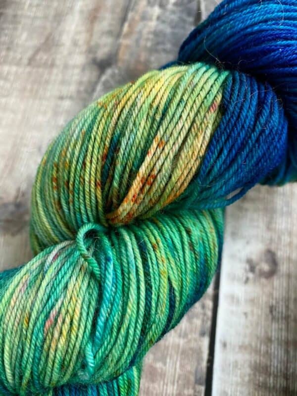 Detail of Incoming Tide, a blue and green hand dyed yarn with orange speckles