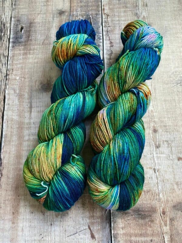 Flat lay of two skeins of Incoming Tide colourway yarn on table