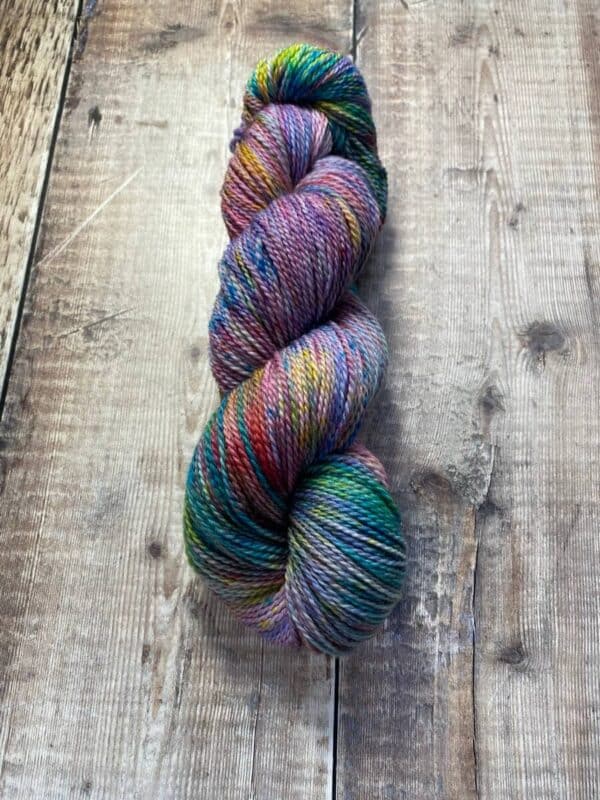 Skein of variegated jewel toned yarn in multicolours, on table